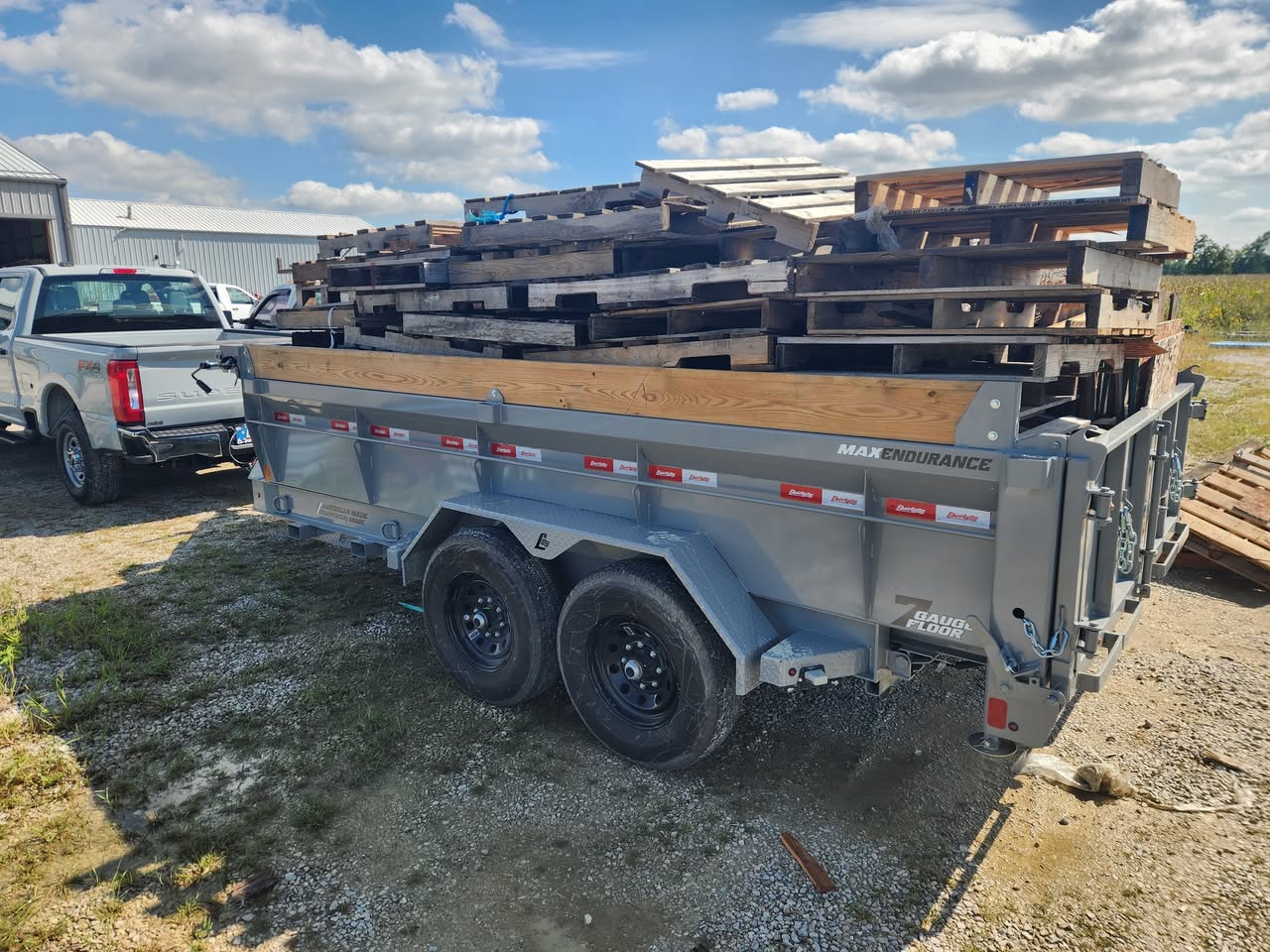 Dump trailer fully loaded with stacked wooden pallets during a commercial junk removal job.