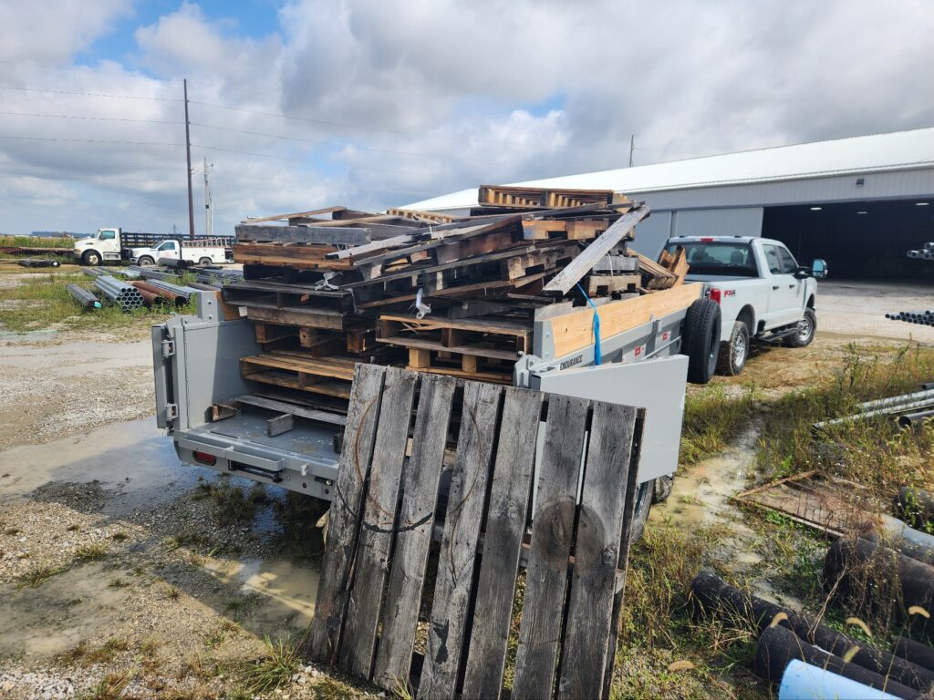 Photo of industrial wood palettes stacked neatly on pickup truck trailer for junk removal